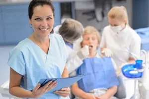 smiling dental hygienist and patient in chair