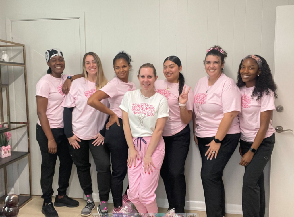 Staff members wearing pink t-shirts and black pants 
