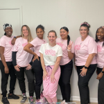 Staff members wearing pink t-shirts and black pants 