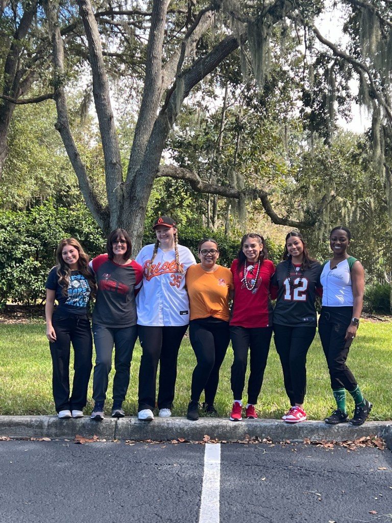 The staff posing under a tree